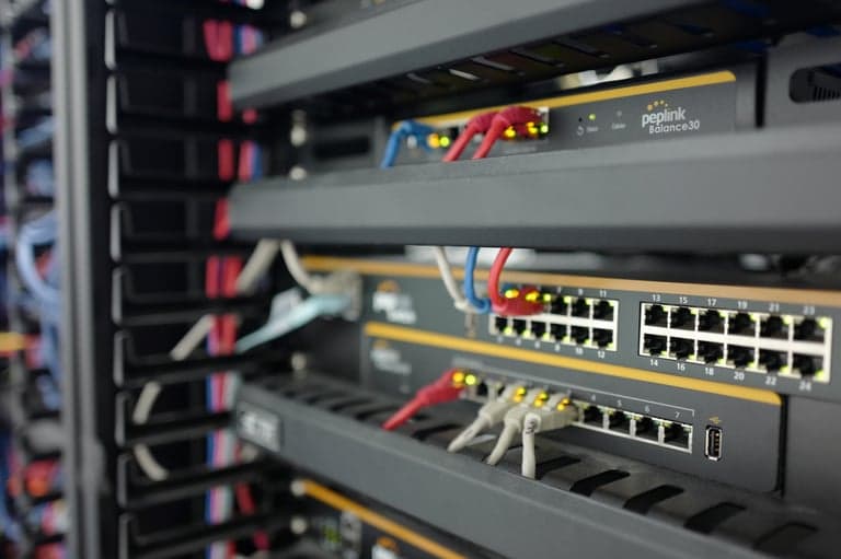 Close-up of Peplink routers cabled in a network rack