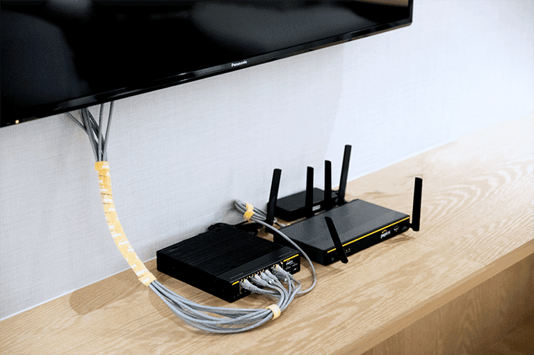 Balance 20X and a second Peplink router installed under a wall-mounted TV